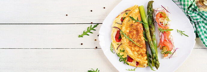 Wall Mural - Ketogenic breakfast. Omelette with tomatoes, red onion, sandwich with salmon and roasted asparagus. Italian frittata. Keto, ketogenic lunch. Top view, banner