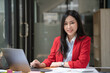 © Songsak C - Asian Businesswoman working on a laptop at her desk at the office.
