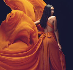 fashion, portrait and woman in orange dress in studio isolated on a black background. beauty, aesthe