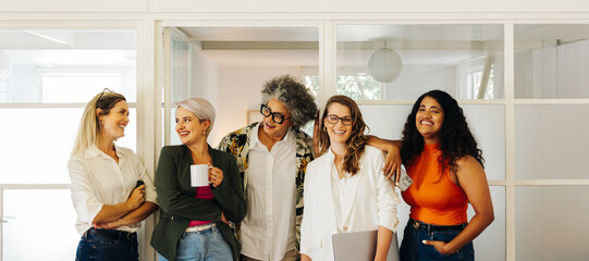 Wall Mural - Happy businesswomen smiling while standing together