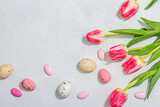 Fototapeta Tulipany - Pink tulips with Easter eggs on light stone concrete background. Festive concept, greeting card