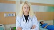 © M Stocker - Caucasian woman plastic surgeon in white uniform, standing with arms crossed and looking at the camera