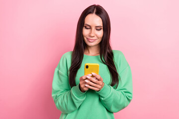 Poster - Photo of young youtube blogger attractive hispanic girl wear green jumper hold samsung phone reading last post isolated on pink color background