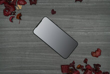 Gray Wooden Background With New Smartphone And Red Leaves For Decoration