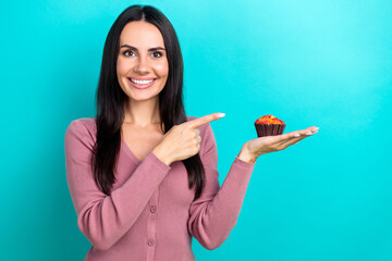 Poster - Photo of nice cheerful lady toothy smile direct finger arm hold muffin dessert isolated on teal color background