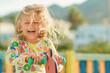 © Maria - sunny summer day excited happy smiling face child girl in yellow dress play on colored wooden children playground in kindergarten