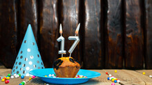 Beautiful Anniversary Background Happy Birthday With A Cupcake And A Burning Candle. Happy Birthday Anniversary On Wooden Background With Decorations With Number 17.