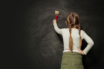 Wall Mural - Child girl painting on school blackboard. Back to school, education, student, pupil