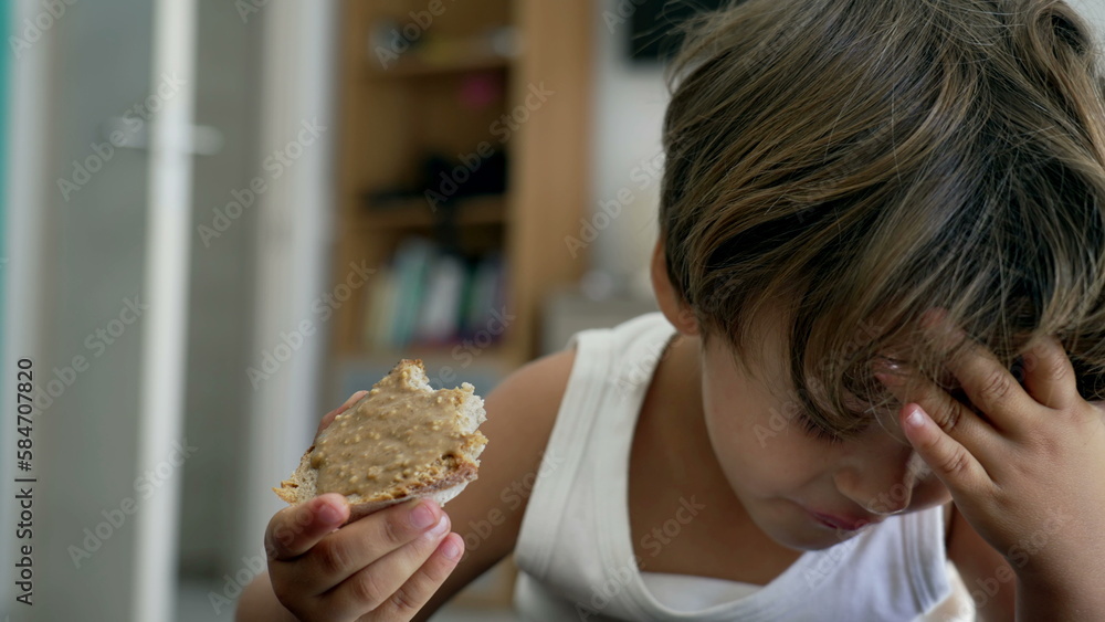Portrait of a young boy snacking peanut butter bread. Closeup child ...
