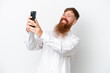 © luismolinero - Redhead man with long beard isolated on white background making a selfie