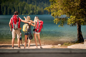 Wall Mural - friends enjoying a day at the lake. young tourist people