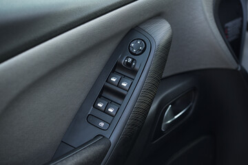 close-up of the side door buttons: window adjustment buttons, door lock. modern car interior: parts, buttons, knobs