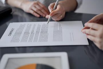 Business people signing contract papers while sitting at the glass table in office, closeup. Partners or lawyers working together at meeting. Teamwork, partnership, success concept