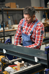 Adult worker connecting metal parts in factory