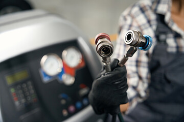 Wall Mural - Repairman using special flushing system for car air conditioner