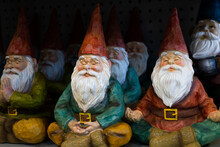 Selective Focus View Of Rows Of Cute Decorative Garden Gnomes In Yoga Or Meditation Poses 