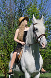 Fototapeta Konie - teenage girl with long hair horseback riding in sunny day