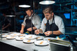 © Manu Padilla/Stocksy - Male cooks garnishing dishes in restaurant