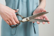 © Helene Cyr/Stocksy - Hands holding scissors