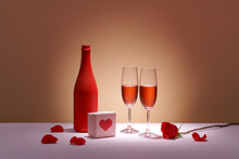 Bottle Of Rose Wine, Two Glasses With Drink, Small Bouquet