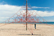 © Ivan Gener/Stocksy - Boy playing on a rope net at the beach