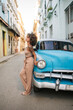 © Daniel Gonzalez/Stocksy - Cuban leaning on vintage vehicle