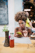 © Daniel Gonzalez/Stocksy - Cuban woman browsing social media in cafeteria