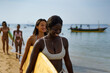 © Jovo Jovanovic/Stocksy - Happy women carrying surf boards on the beach on a sunny day