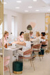 © Alina Hvostikova/Stocksy - Professional manicurists giving manicure to clients