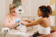 © Alina Hvostikova/Stocksy - Smiling black woman getting manicure