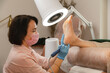 © Alina Hvostikova/Stocksy - Female beautician treating heel skin area