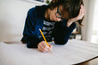 © Maria Manco/Stocksy - Boy does homework at home