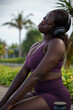 © Jovo Jovanovic/Stocksy - Woman wearing headphones stretching her neck with her eyes closed