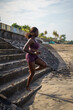 © Jovo Jovanovic/Stocksy - Woman running down the stairs towards beach