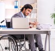 © Elnur - Young handsome employee in wheelchair at the office