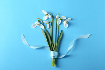 Wall Mural - Beautiful snowdrops on light blue background, flat lay