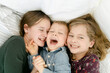 © Léa Jones/Stocksy - happy siblings snuggling  and laughing