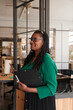 © Malquerida Studio/Stocksy - Entrepreneur standing and looking documents at workplace