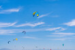 © Daniel Gonzalez/Stocksy - Colorful power kites in blue sky