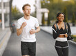 © prostooleh - African-american woman and caucasian man jogging at the stadium