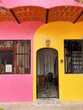 © Simone Anne/Stocksy - Pink and yellow house with gate