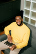 © Artem Podrez/Stocksy - A black man works at a laptop in his apartment