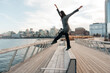 © Yakov Knyazev/Stocksy - young female dancing on a bench in the park, making giant step