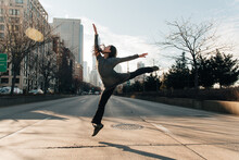 Young Female Dancing In The Street On A Crossroad, High Leaps