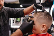 © Cavan - Adult male barber lining up child's edges in Portland, Oregon