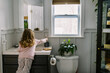 © Serena Burroughs/Stocksy - happy toddler girl in bathroom brushing her teeth by herself