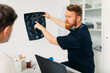 © Studio Firma/Stocksy - Doctor Showing X -Ray Image to Patient