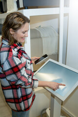 Wall Mural - Woman uses the self-service kiosk in the store.