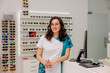 © VICTOR TORRES/Stocksy - Smiling optometrist in store with eyeglasses