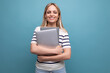 © Ivan Traimak - casual confident young woman student in casual clothes with laptop on blue isolated background with copy space